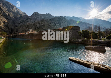 Journée d'hiver ensoleillée paysage urbain de la vieille ville de Kotor avec les murs de défense du Nord et les eaux de la rivière vert Scurda. Voir avec les rayons du soleil un Banque D'Images