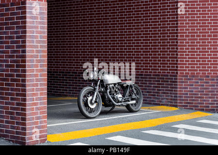 Parking moto artisanal près de mur de briques de bâtiment industriel. Tout est prêt pour s'amuser après une dure journée au bureau. Businessman ville hipst Banque D'Images