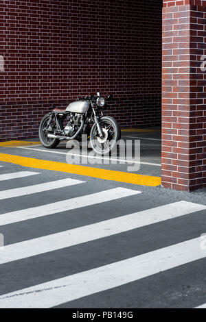 Parking moto vintage près de mur de briques de bâtiment industriel. Tout est prêt pour s'amuser après une dure journée au bureau. Hipste ville d'affaires Banque D'Images