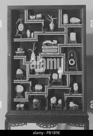 Vitrine contenant 25 ornements. Culture : la Chine. Dimensions : a. Pendentif oiseau : H. 2. (5,1 cm) ; W. 1 3/4 in. (4.4 cm) b. Homme debout : H. 2. (5,1 cm) c. Homme debout : H. 1 3/8 in. (3,5 cm) d. Fleur et feuille : H. 1. (2,5 cm) ; L. 1 1/8 in. (2,9 cm) e. Bouquet floral. H. 1 1/8 in. (2,9 cm) ; Diam. 1 1/2 in. (3,8 cm) f. Vase avec coral spray : H. 1 7/8 in. (4,8 cm), (vase) g. Arbre et oiseau : H. 3 5/8 in. (9,2 cm) h. 2 petits animaux : H. 1 3/8 in. (3,5 cm) ; L. 2 1/4 in. (5,7 cm) i. Avec des feuilles de lotus Quartz améthyste : H. 1 1/4 in. (3,2 cm). Vase avec coral spray:H. 4 3/4 in. (12 Banque D'Images