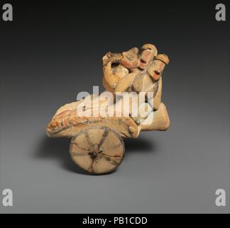 Modèle en terre cuite d'un 'panier'. La culture chypriote :. Dimensions : H. 4 1/4 in. (10,8 cm). Date : ca. 600-480 av. J.-C.. Trois chiffres sont couchée sur une surface horizontale avec des roues. Les grandes figures, l'homme et de la femme, le soutien eux-mêmes sur les coussins tandis que le troisième, plus petit personne joue le double flûte. La représentation immédiatement suggère la encore de contingent d'une ancienne 'chypriote défilé." Cependant, il est bon de se rappeler les chariots à roues qui ont participé à des processions athénienne ; plus notable est le navire à roues dans le festival de l'Anthesteria dédié à Dionysos. Le 'panier' ici je Banque D'Images