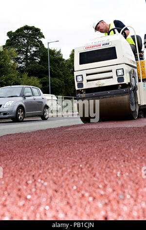 Rouge de pose de l'asphalte sur une route au Royaume-Uni Banque D'Images