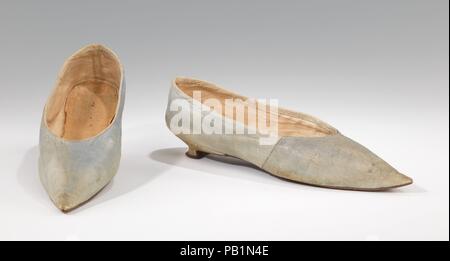 Des chaussons. Culture : probablement britanniques. Date : 1795-1810. La transition de la chaussures à talons hauts de 18e siècle 19e siècle télévision de styles est illustrée par cette paire de chaussons de couleur délicatement. Les pointues toe est devenue à la mode dans les années 1780, et est resté le style préféré pendant environ vingt-cinq ans comme le talon diminué à néant. Vu ici est un exemple classique de la 'Italienne', talon assez court avec un siège, effilé coincé profondément marquée et de torchage sur une petite pièce supérieure. Les chaussures sont façonnés avec soin en blanc, et magnifiquement polies sur la plante. Musée : Banque D'Images