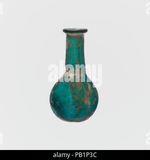 Flacon de parfum en verre. Culture : Roman. Dimensions : 1 1/2 in. (3,8 cm) Diam. de la jante : 3/8 in. (1 cm) Longueur : 13/16 in. (2 cm) Largeur : 16 in. (1,7 cm). Date : 1er siècle de notre ère. Flacon de parfum miniature profond translucide vert turquoise. De plus, Rim, et dans, sur le dessus aplati ; long, cou légèrement conique, estampé dans autour de base ; lentoid avec corps en deux parties recouvertes de tirets ; fond rond. Piqûre intact ; et quelques très grosses bulles ; ternissement et correctifs de météorisation irisé. Musée : Metropolitan Museum of Art, New York, USA. Banque D'Images