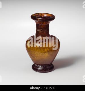 Bouteille miniature en verre. Culture : Roman. Dimensions : Hauteur : 1 5/8 in. (4.1 cm) Diam. : 1 1/16 x 3/4 x 3/4 in. (2,7 x 1,9 x 1,9 cm). Date : 3e et 4e siècle de notre ère. Profond translucide Honey Brown. Bord arrondi, lissées à côtés de la torche de la bouche ; bref, concave, cou cylindrique ; légèrement courber l'épaule ; corps piriforme effiler vers le bas ; d'épaisseur, à base arrondie anneau sous petit, fond plat. Cassé et réparé avec des jetons dans la jante et deux trous de piqûre ; corps ; bulles et ternir légèrement irisés sur l'extérieur et faible altération blanchâtre sur l'intérieur. Musée : Metropolitan Museum of Art, New York, U Banque D'Images