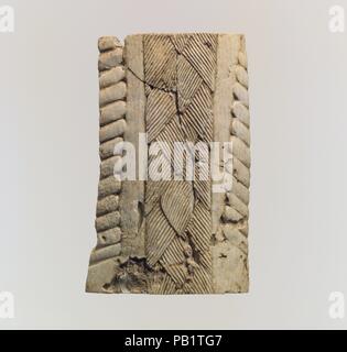 Fragment d'Ivoire. Culture : l'assyrien. Dimensions : 3.27 x 2.09 x 0.63 in. (8.31 x 5.31 x 1.6 cm). Date : ca. 9ème-7ème siècle avant J.-C.. Cette plaque a un dos plat et une surface élevée, sculptés en relief avec une conception centrale ressemblant à des cheveux tressés ou des touffes de poils, bordé de chaque côté avec une bande lisse et un bord cannelé. Il doit avoir été partie d'un autre objet, comme une statue ou un meuble, mais a été constaté comme un fragment, de sorte qu'il est difficile de reconstruire la conception originale. Pièces en ivoire sculpté, comme cela a été largement utilisé dans la fabrication de meubles d'élite au début première millen Banque D'Images