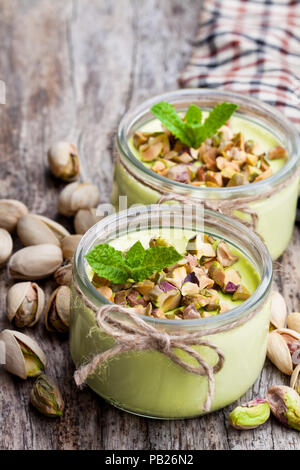 Pistache naturelle le yogourt dans un petit bocal en verre sur la table en bois Banque D'Images