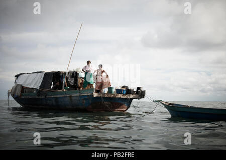 Une famille Bajau passent leurs journées et nuits vivant ensemble sur un bateau au large de la côte de Mabul Island. Alignés à aucun pays inelligable ils sont d'obtenir des soins médicaux et de l'éducation de n'importe où. Exilé de l'origine, les Philippines ces personnes trouvent refuge autour de Mabul Island car il n'est pas surveillée en raison d'être une île privée entre les Philippines et la Malaisie. Spands la vie sont courtes elles ne reçoivent que l'expérience de la vie que l'éducation. Ils sont les gitans de la mer. Banque D'Images