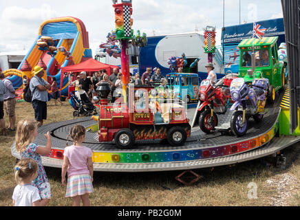 Un rond-point ou Carousel pour enfant, des promenades en train, tracteur, Motos, bus et voiture au Salon de l'agriculture à Nantwich Cheshire England Royaume-Uni UK Banque D'Images