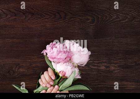 Femme avec les mains manucure rose pivoines hold Banque D'Images