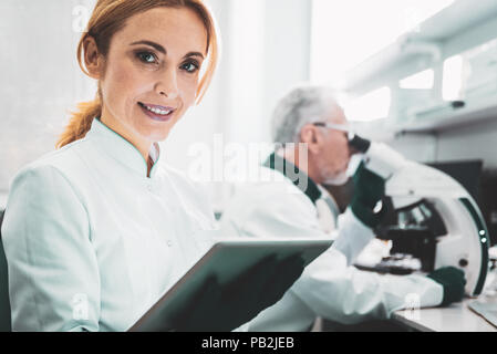 Smiling chemist portant des gants noirs dans la recherche prix Banque D'Images