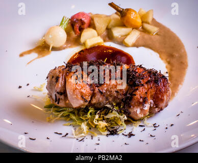 Plat de Laszlo Papdi de l'hôtel Lenkerhof, Lenk, Suisse. Caille à la crème de champignons porcini, pomme caramélisée au calvados, paille de poireaux Banque D'Images