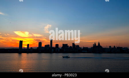 Le soleil se lève derrière la skyline de Liverpool à partir de la gare maritime de Woodside à travers le fleuve Mersey. Les températures devraient atteindre 35°C aujourd'hui que la canicule se poursuit à travers le Royaume-Uni. Banque D'Images