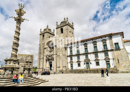 Vue grand angle d'un jeune couple assis sur les marches de la culo de Porto (Pelourinho do Porto) avec la Cathédrale de Porto et musée du trésor en Banque D'Images