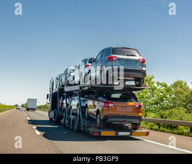 Remorque porte-voiture avec de nouvelles voitures sur la plate-forme superposés. Transport de voiture camion sur l'autoroute Banque D'Images