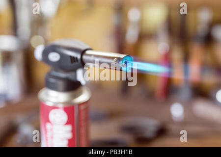 Pistolet à cartouche de gaz plus léger .Close-up la buse du brûleur avec jet de flamme bleu. Atelier de bois brûlant, Banque D'Images