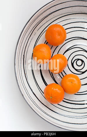 Easy peel 5 mandarines dans un grand bol de fruits avec une configuration en spirale sur un fond blanc Banque D'Images