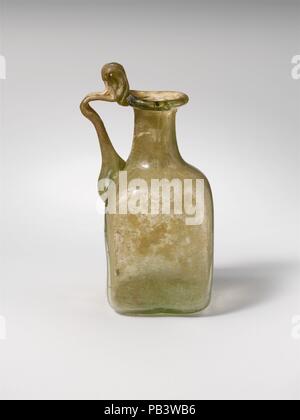 Bouteille en verre. Culture : Roman. Dimensions : hors tout : 3 x 5/16 1 7/16 x 1 7/16 in. (8,4 x 3,7 x 3,7 cm) Diam. : 7/8 in. (2,2 cm). Date : 1re, 3e siècle de notre ère. Les petits traités flacon carré. Jaune Vert translucide ; poignée de même couleur. Rim dépliées, ronde, et dans, et pressé dans d'autre de la bouche, du cou cylindrique, l'extension vers le bas ; oblique ; corps carré avec des côtés inégaux et arrondie coins inférieurs ; fond plat ; deux poignée striée est attaché à l'épaule, établis à l'extérieur, tourné à l'horizontale, et traînées sur le bord extérieur de la jante avec la boucle ci-dessus. D'un côté, modèle resem soulevé Banque D'Images