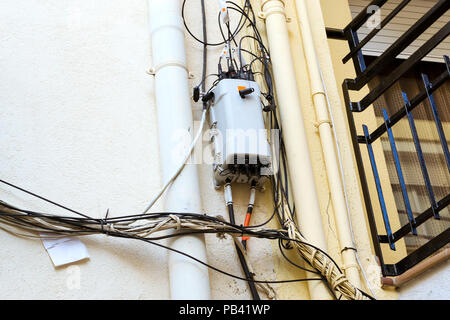 Câbles d'alimentation électrique à haute tension, câbles de téléphone et d'internet en face de la façade de l'immeuble. Architecture de l'espagnol en été Blanes beach resort Banque D'Images