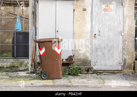 Poubelle marron à l'arrière d'un secteur de la rue urbaine . Banque D'Images