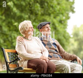 Couple assis sur un banc à l'extérieur Banque D'Images