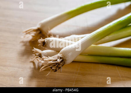 Laver les oignons de printemps sur une planche à découper de cuisine. Banque D'Images