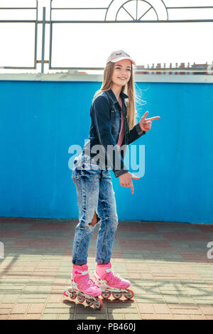 Teenage girl wearing patins à s'amuser sur trottoir en ville Banque D'Images