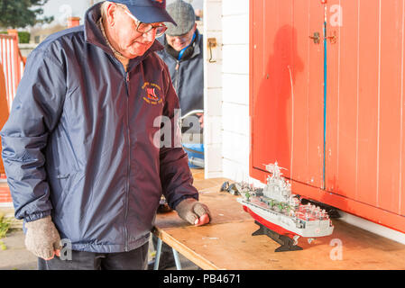 Homme mature avec son navire de combat radio-commandé, Ramsgate, Kent, Angleterre, Royaume-Uni. Banque D'Images