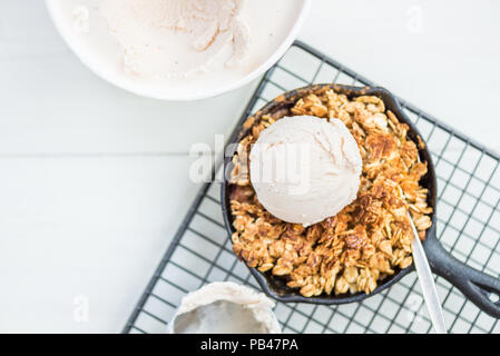 La rhubarbe cuite faits maison et crumble aux pommes avec glace à la vanille et à l'avoine dans le fer à repasser Cuisine Banque D'Images