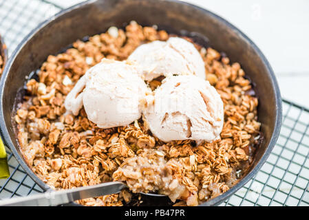 La rhubarbe cuite faits maison et crumble aux pommes avec glace à la vanille et à l'avoine dans le fer à repasser Cuisine Banque D'Images