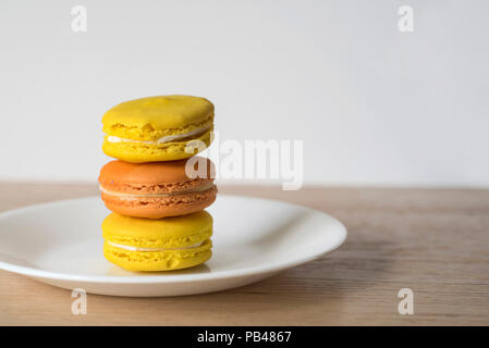 Close-up avec les couleurs chaudes de jaune et orange macarons empilés Banque D'Images