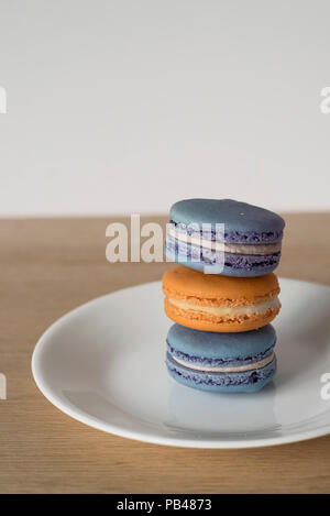 Pile de macarons français / Macarons en bleu et orange, un snack sucré et délicieux Banque D'Images