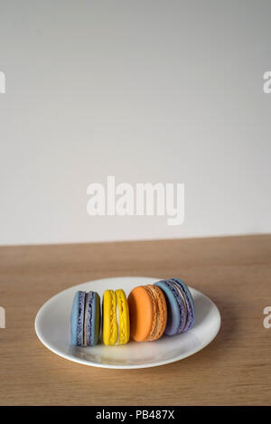 Macarons colorés debout sur une plaque Banque D'Images