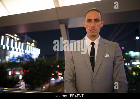 Young Handsome Businessman Outdoors at Night Banque D'Images