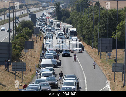 Pour les files d'Eurotunnel de Folkestone, Kent, remontent vers l'autoroute M20 en tant que passagers en utilisant les services cross-canal ont été mis en garde contre des retards allant jusqu'à cinq heures après l'échec de la climatisation dans les trains au milieu des températures brûlantes. Banque D'Images