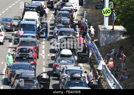 Pour les files d'Eurotunnel de Folkestone, Kent, remontent vers l'autoroute M20 en tant que passagers en utilisant les services cross-canal ont été mis en garde contre des retards allant jusqu'à cinq heures après l'échec de la climatisation dans les trains au milieu des températures brûlantes. Banque D'Images