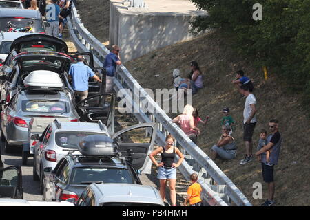 Pour les files d'Eurotunnel de Folkestone, Kent, remontent vers l'autoroute M20 en tant que passagers en utilisant les services cross-canal ont été mis en garde contre des retards allant jusqu'à cinq heures après l'échec de la climatisation dans les trains au milieu des températures brûlantes. Banque D'Images