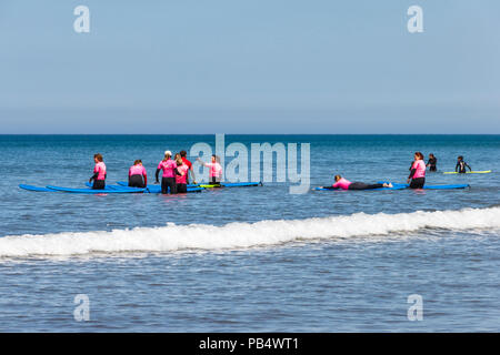 Un groupe de femmes internautes de prendre des leçons dans la mer à Westward Ho !, Devon, UK Banque D'Images