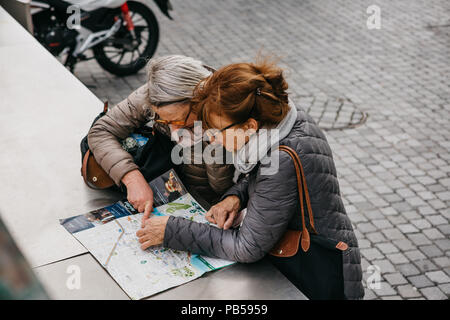 Porto, Portugal, 05 mai 2018 : deux personnes âgées amis féminins ou les touristes à la recherche d'un plan de la ville pour plus de voyager et de discuter. Banque D'Images