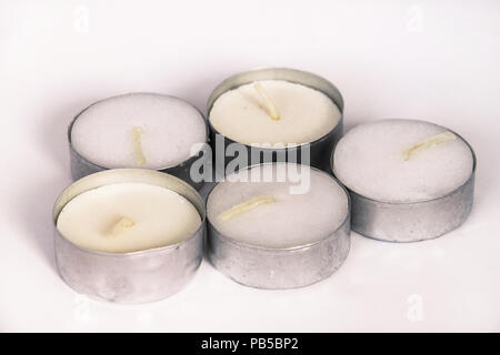 Groupe de petites bougies blanches sur fond blanc Banque D'Images