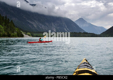 Deux kayaks sur la pagaie Plansee, Woman in red kayak Kayak sur Plansee, Autriche Banque D'Images