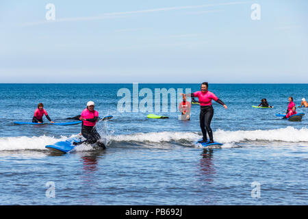 Un groupe de femmes internautes de prendre des leçons dans la mer à Westward Ho !, Devon, UK Banque D'Images