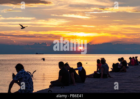 Trieste, Italie, 26 juillet 2018. Les gens profiter du coucher du soleil à partir de l'emblématique Molo Audace Audace (Pier) dans le nord de l'Italie ville de Trieste. Le 246-mete Banque D'Images