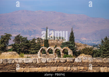 Mosquée sur une colline avec des montagnes en arrière-plan sur une journée ensoleillée et ciel bleu à Anjar, vallée de la Bekaa, au Liban Banque D'Images