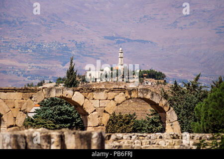 Mosquée sur une colline vu de ruines Omeyyades avec montagnes en arrière-plan sur une journée ensoleillée à Anjar, vallée de la Bekaa, au Liban Banque D'Images