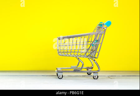 Store shopping concept panier miniature sur fond jaune Banque D'Images