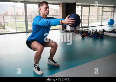 Beau Jeune homme faisant équipe avec ballon dans le cadre de la formation de culturisme Banque D'Images