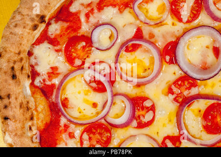 Pizza chaude close-up. L'oignon au fromage et tomate sur base de levain de brûlée. Confort alimentaire italienne classique. Banque D'Images