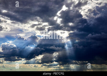 Un ciel nuageux avec des rayons de soleil qui brillait à travers les nuages Banque D'Images