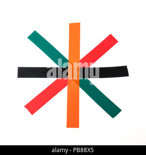 Quelques bandes de ruban isolant de couleur croix sur une surface blanche Banque D'Images